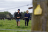 Two couple walking across the green field