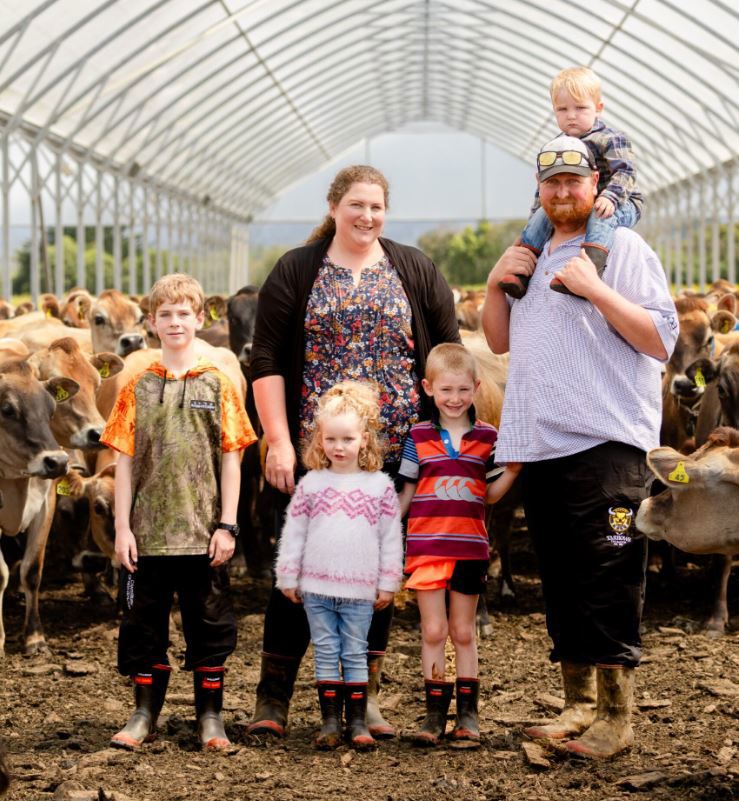 New Zealand dairy farmers Mike and Sheree and family, in a stand-off shelter with Jersey cows