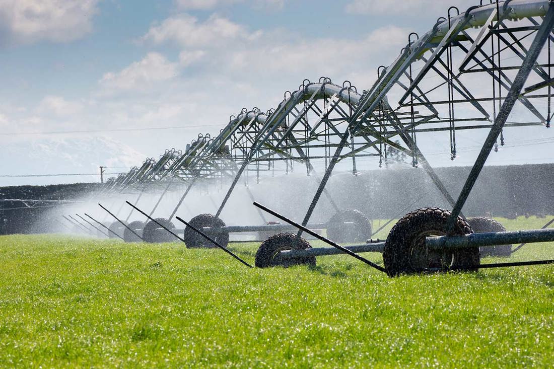 A travelling irrigator working in a grass paddock.