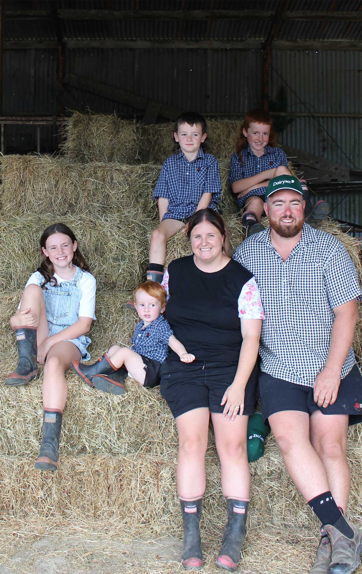 Josh and Emma Crawford and family in the dairy farm barn
