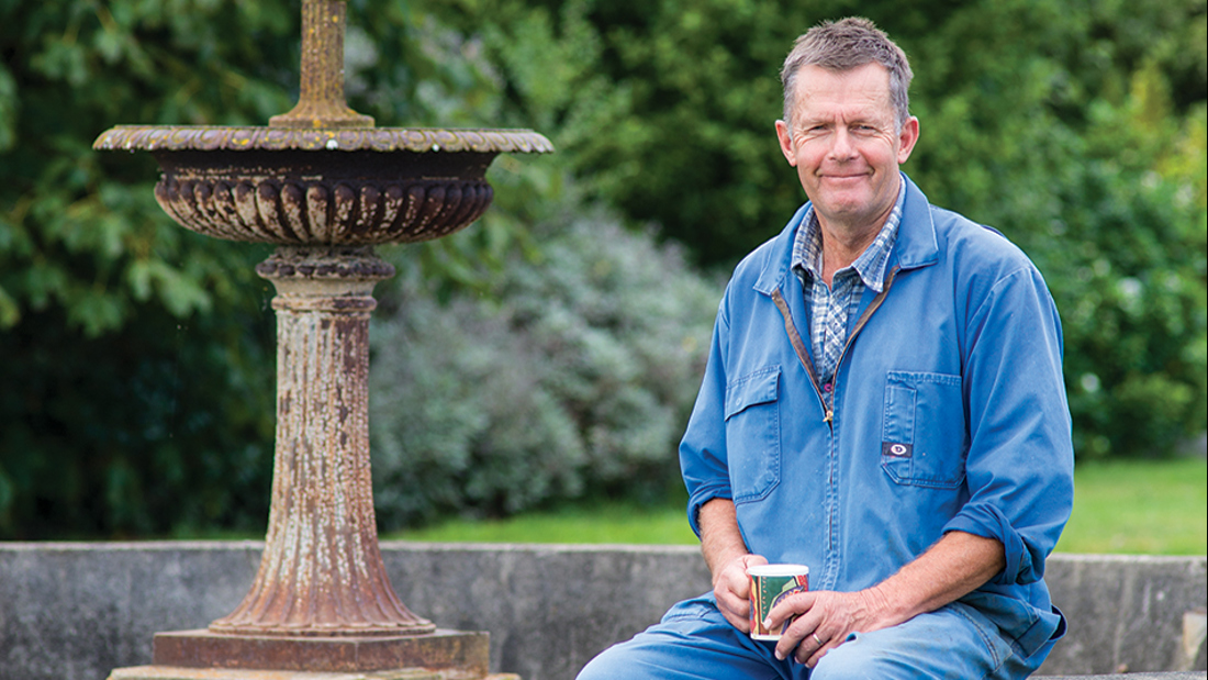 A man sitting down holding a mug
