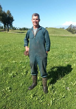 New Zealand dairy farmer Richard Fowler standing in a plantain paddock on his farm.