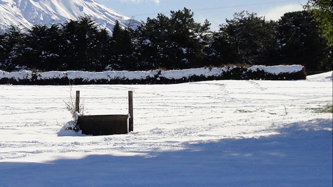Snow covered field with well