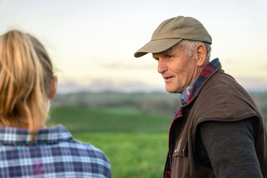 A New Zealand dairy farmer talking to a DairyBase reqpresentative about farm data