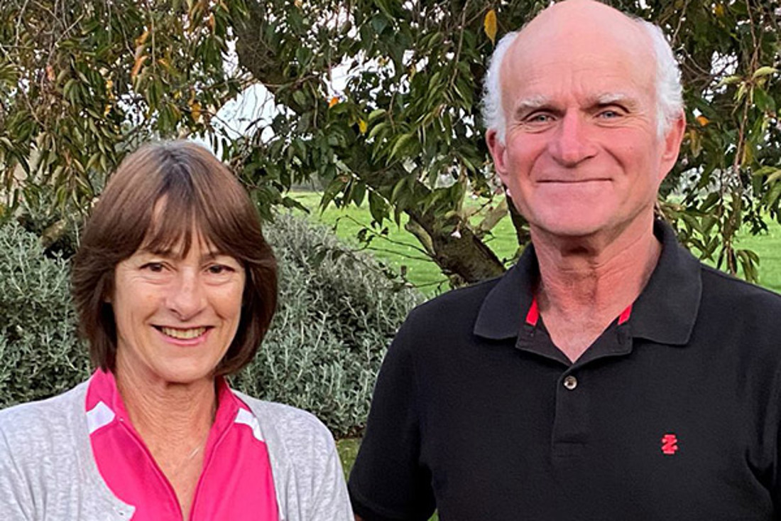 a man and woman with a large tree in the background
