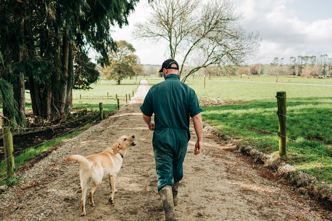 A farmer walks alongside his dog