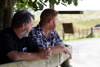Two dairy farmers leaning on a fence and talking
