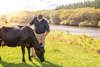 Dairy farmer Luke Templeton in a paddock with a dairy cow on his Southland farm